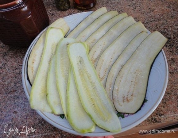 Кабачки и баклажаны нарезать длинными пластами, разложить на блюде и слегка посолить. Оставить на 15 минут.