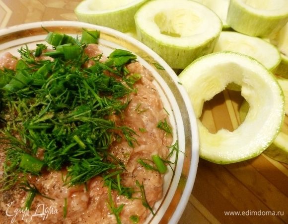 Кабачок вымыть и нарезать поперёк на одинаковые шайбочки. Ножом вырезать середину. Приготовить фарш из любого мяса(все на ваш вкус) с луком и чесноком. Приправить солью, перцем, добавить хмели-сунели. Зелень петрушки и укропа измельчить и тоже положить в фарш. Кабачковые кольца можно проварить 2–3 минуты, чтобы они стали помягче, если вы вдруг не любите чтобы они хрустели.