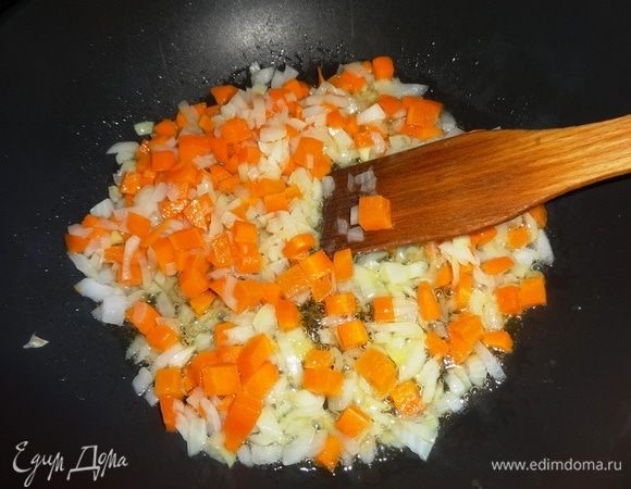 В сковороду налить масло для риса и овощей, разогреть его. Положить лук и морковь, обжарить, помешивая, до золотистого цвета.