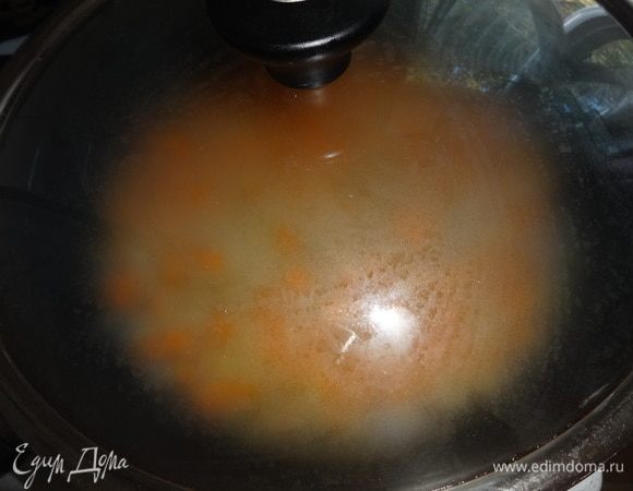 Огонь убавить, накрыть сковороду крышкой и готовить рис до почти полного впитывания жидкости. Это займет примерно 25–30 мин.