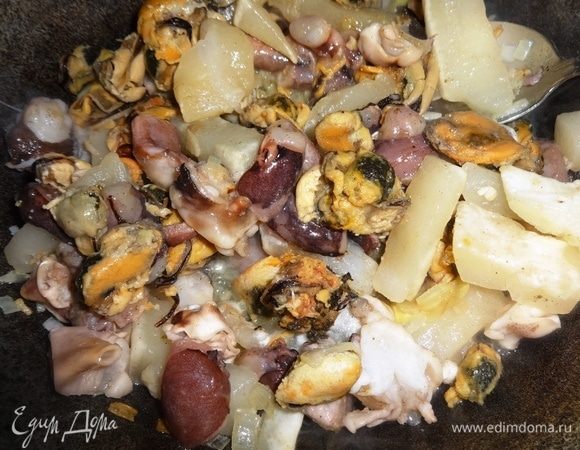 К обжаренным овощам добавить размороженный морской коктейль, перемешать. Жарить, помешивая, 5–7 мин.