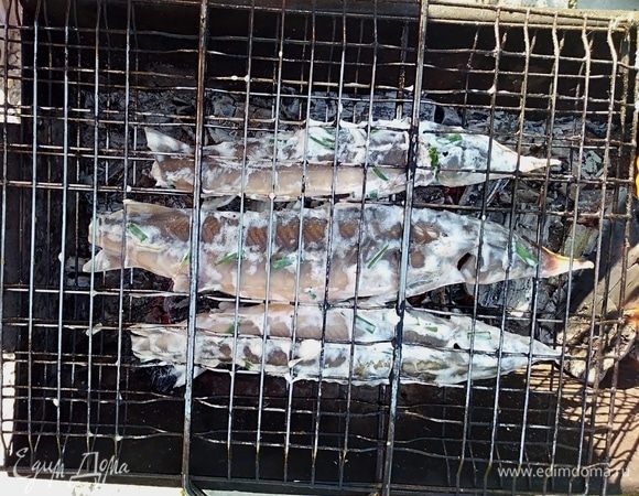 Подготовить угли для мангала. Решетку немного смазать маслом. Луком, в котором мариновалась рыбка, начинить тушки. Выложить рыбу. Запекать, переворачивая, 25 минут.