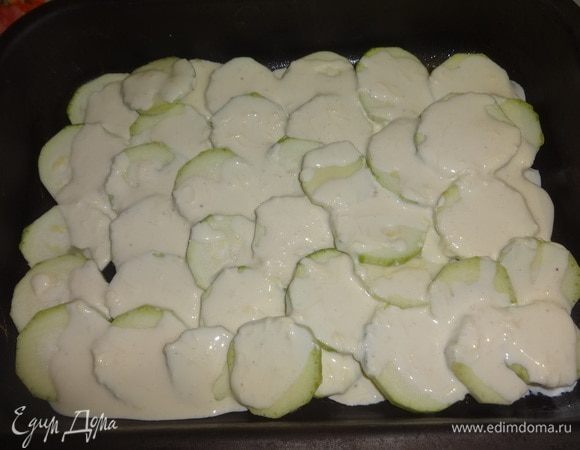 Форму для запекания смазать растительным маслом. Выложить слой кабачковых кружков, немного подсолить их, полить частью заливки. Выложить еще слой кабачков, повторить действия.
