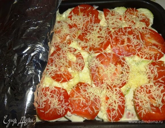 Еще слой кабачков положить, посолить и добавить слой заливки. На заливку выложить слой помидоров, посыпать отложенным тертым сыром. Накрыть форму фольгой. Поставить форму в разогретую до 180°C духовку примерно на 1 час.