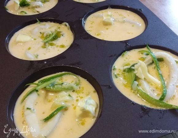 Влить яичную смесь в формочки, сверху положить по кусочку сливочного масла. Запекать в заранее разогретой до 180°C 20 минут.