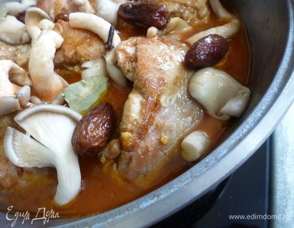 Положить вешенки и финики. Смешать воду и томатную пасту, добавить муку. Тщательно перемешать. Залить курицу с овощами. Положить специи.