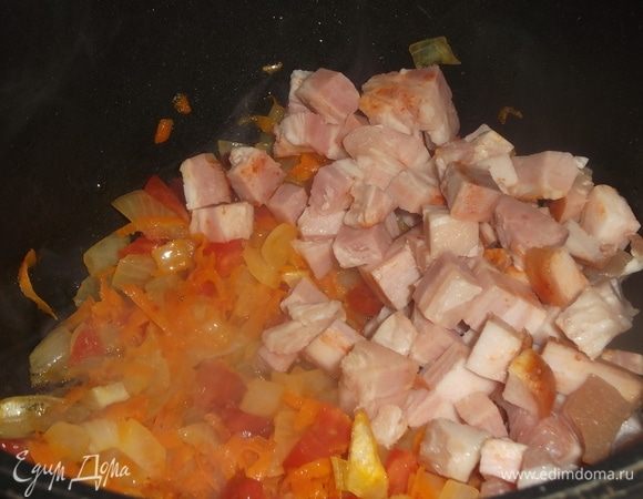 К моркови с луком прибавить нарезанные помидоры, слегка припустить и добавить нарезанную грудинку, пережарить.
