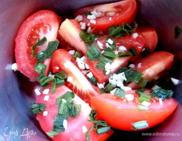 Насыпать в банку или кастрюлю слой помидорных долек, чеснок, лук.