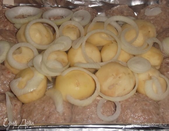 Добавить нарезанный кольцами лук. Накрыть сверху форму фольгой, поставить в разогретую до 200°C духовку.