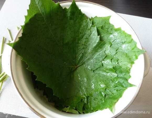 Виноградные листья промыть, обрезать черешки, залить кипятком и оставить, пока вода не остынет до комнатной.