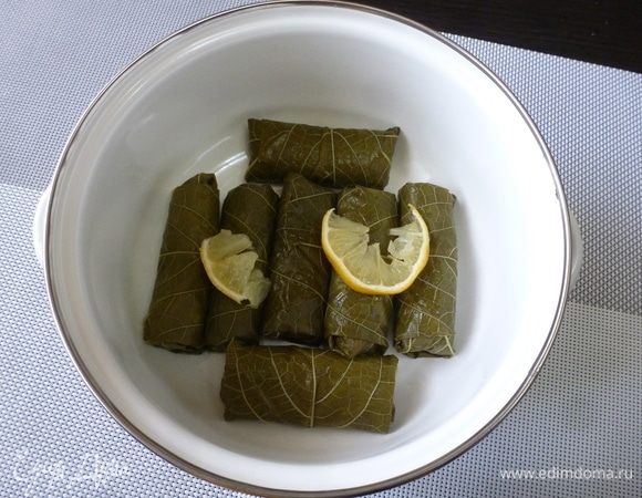 Плотно уложить сарму в кастрюлю, между каждым слоем положить 2–3 колечка лимона.