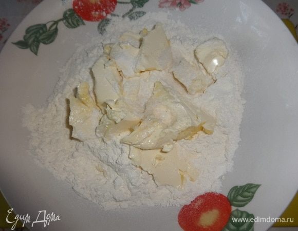 В просеянную муку добавить кусочки сливочного масла, соль и перетереть в крошку.