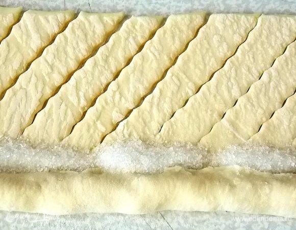 Закрыть изюм тестом и насыпать по краю сахар.