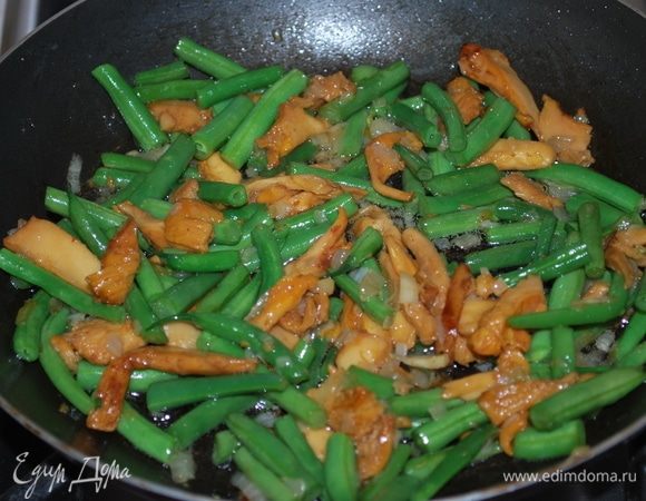 К луку и лисичкам добавим стручковую фасоль и все вместе обжарим несколько минут, солим и перчим по вкусу.