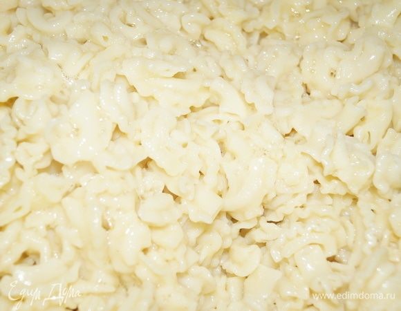 В макароны добавляем яйца, перемешиваем их и выкладываем в форму первым слоем около 3–4 см.