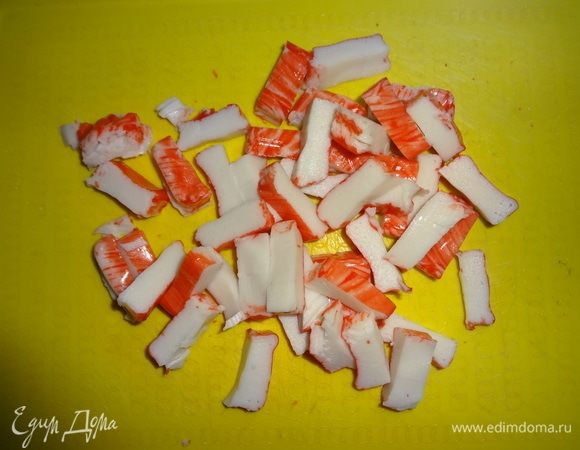 Крабовые палочки нарезать небольшими кусочками. Выложить в тарелку.