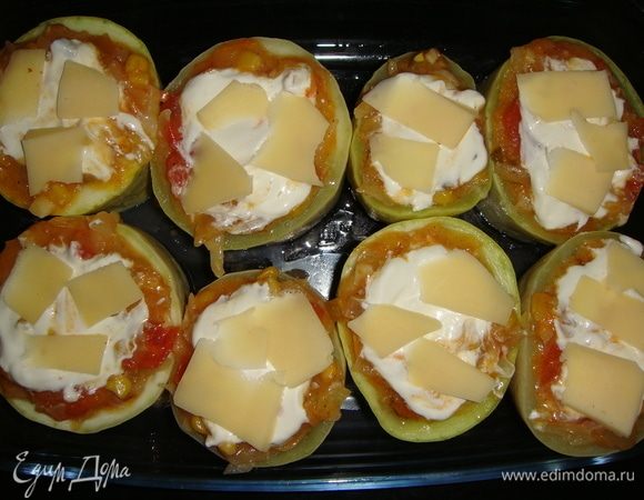 Сверху положить по 1 чайной ложке сметаны и тонко нарезанный пластинками сыр. Запекать в разогретой до 200°C духовке 25–30 минут.