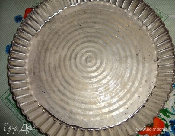 Форму смазать растительным маслом. Из пергамента вырезать круг диаметром дна формы и уложить его на дно. У меня металлическая форма с ребристыми краями. Внутренний диаметр — 23,5 см, внешний — 25,5 см.