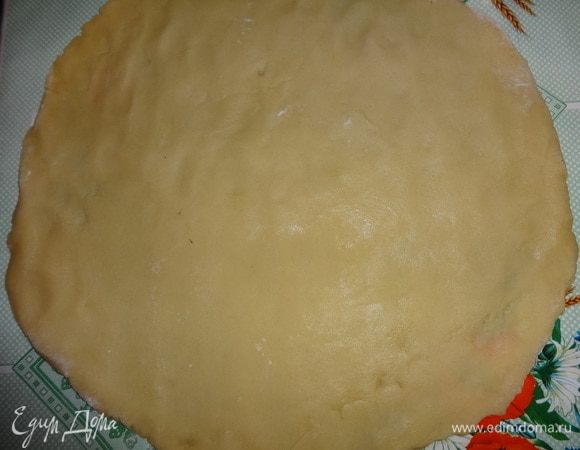 На стол насыпать немного муки. Достать тесто из холодильника. Отделить 2/3 части теста и раскатать его в круг диаметром больше диаметра дна формы, или диаметр дна формы + размер бортиков.