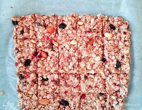 Выложить на застеленный бумагой для выпечки противень. Сделать надрезы ножом, разделив пласт на прямоугольнички. Выпекать 15 минут при температуре 180°C.