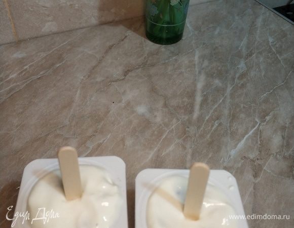 Закрываем ягодки йогуртом и аккуратно вставляем палочки от мороженого. И в холодильник на 3–4 часа, а лучше — на ночь.