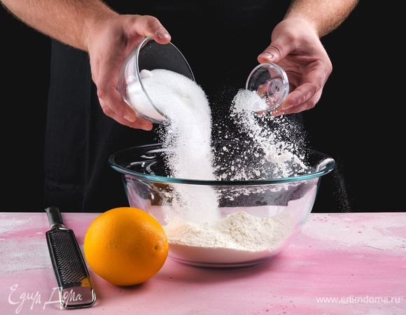 В глубокой емкости соедините пшеничную муку, сахар, разрыхлитель, апельсиновую цедру.