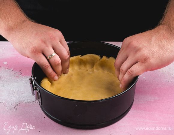 Разъемную форму диаметром 20 см смажьте сливочным маслом. Охлажденное тесто раскатайте, выложите в форму, сформируйте высокие бортики.