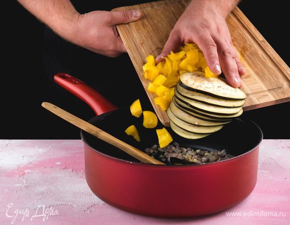 Баклажан нарежьте тонкими кружками, сладкий перец удалив семена и плодоножку, нарежьте небольшими кубиками, добавьте в сковороду, и все перемешайте.<br />
 