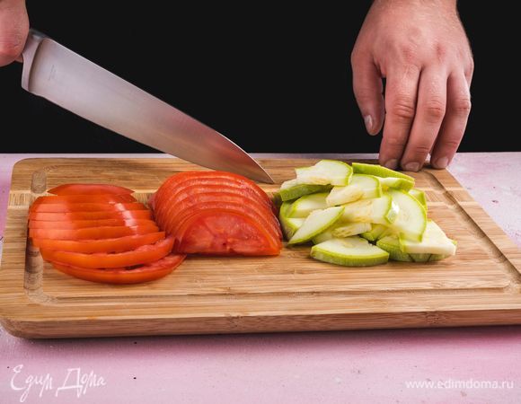 Кабачок нарежьте тонкими ломтиками. Помидор нарежьте небольшими кусочками.<br />
 