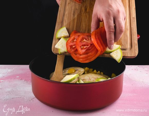 В сковороду с овощами добавьте помидор и кабачок, слегка посолите, перемешайте и все обжарьте.