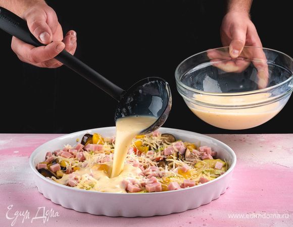 В форму выложите овощи, добавьте ветчину и натертый сыр, сверху вылейте яично-молочную массу.<br />
 