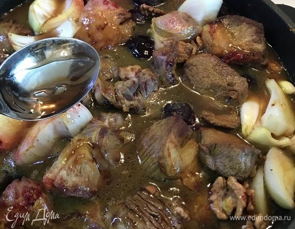 Добавить в кастрюлю с ягнятиной сливы, лук и зубчики чеснока, полить и залить водой так, чтобы мясо на 1 см выступало из воды.