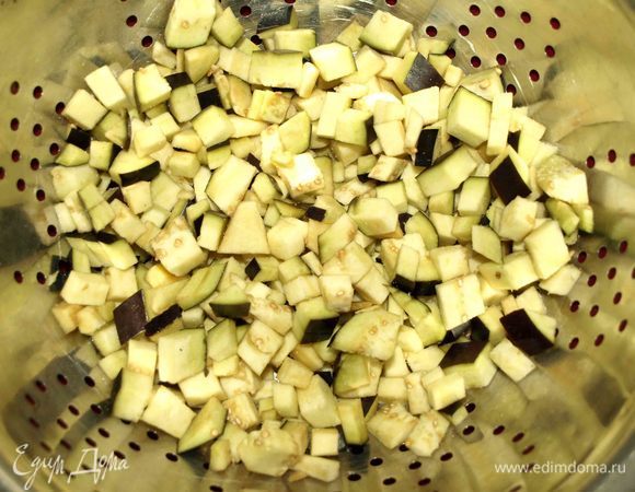 Баклажан промыть, очистить от плодоножки. Нарезать кубиками, посыпать солью и оставить на 20 минут, чтобы убрать горечь.