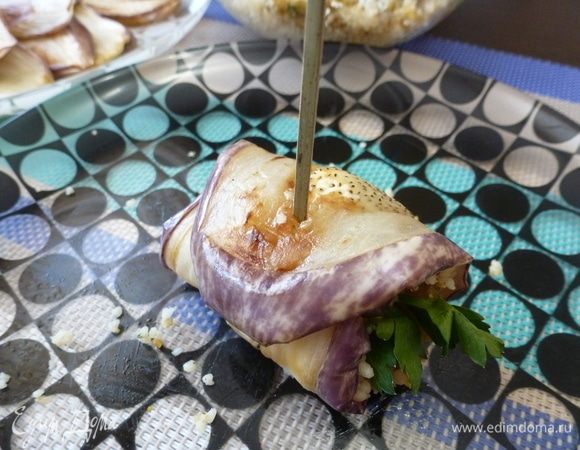 На обжаренную пластинку баклажана выложить начинку из кускуса с курагой и орехами. Свернуть в рулет и заколоть шпажкой. Для красоты я положила целые листики петрушки.