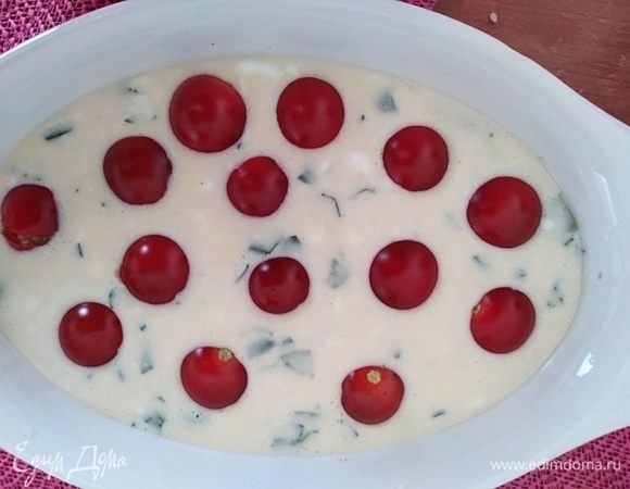 Формочки смазать растительным маслом, распределить тесто по формочкам, сверху разложить помидорки.