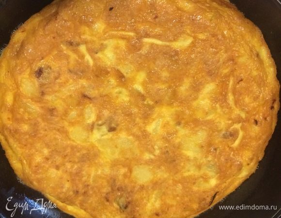 Когда нижний слой будет готов, аккуратно при помощи тарелки перевернуть тортилью на другую сторону, накрыть крышкой и жарить еще 2–3 мин.