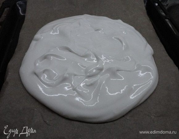 Лучше сразу же включить духовку для разогрева до 140–150°C. Белки на небольшой скорости взбиваем до появления пены, затем добавляем лимонный сок, увеличиваем скорость и, когда белки побелеют, загустеют, начинаем добавлять по одной столовой ложке смесь мелкозернистого сахара с крахмалом и ванильным сахаром. На пергаменте я нарисовала карандашом круг, но фактически корж оказался больше. А белки (это я уже на будущее) надо распределять даже потолше к краям и лопаткой или ложкой побольше «волн». Запекаем 50–60 минут.