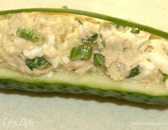 Наполняем огурцы салатом. Посыпаем любой зеленью. Выкладываем на блюдо и подаем к столу.