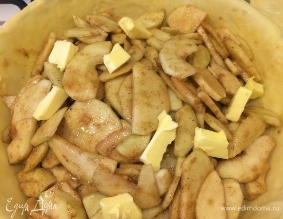 Достать форму с тестом, переложить яблочную начинку в форму, сверху положить кусочки холодного масла.