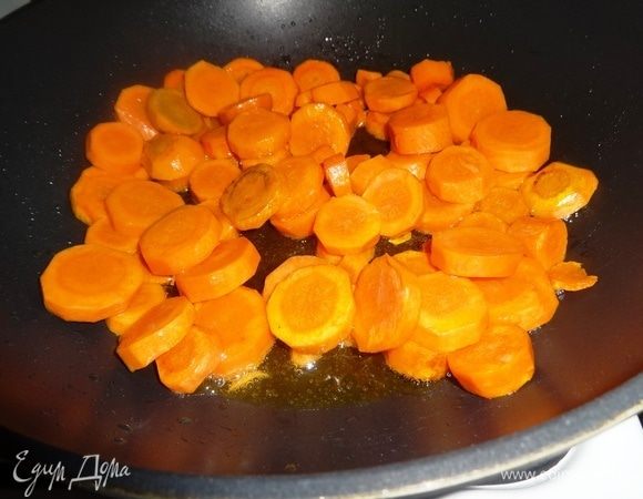 В сковороду налить оливковое масло, разогреть. Выложить морковь и обжаривать 5 мин. на сильном огне, все время помешивая.