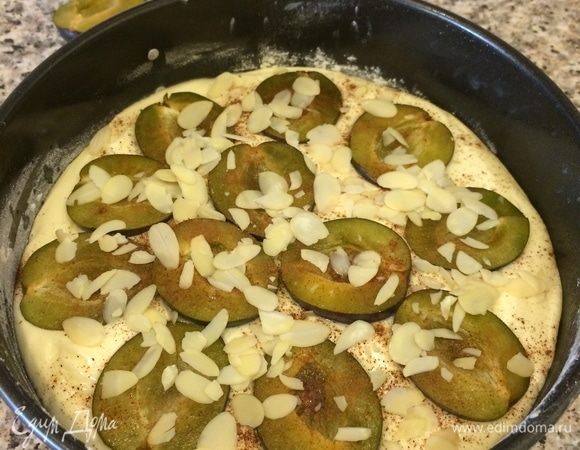 Сверху выложить половинки слив, полить лимонным соком, посыпать корицей и миндальными лепестками.