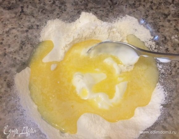 Духовку нагреть до 180°C. Растопить 50 г масла. В миску просеять муку, добавить соль, разрыхлитель, растопленное масло, сметану, все хорошо перемешать.