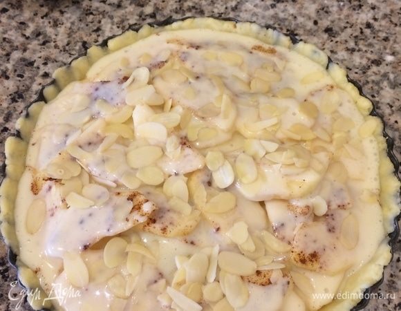 Сверху положить яблоки, посыпать корицей, залить кремом и посыпать миндальными лепестками.