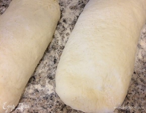 Затем сформировать продолговатые заготовки и уложить для расстойки швом вниз на рабочую поверхность, которую нужно хорошо посыпать мукой (я посыпала цельнозерновой мукой).