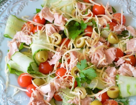 На широкое блюдо выкладываем первым слоем петрушку, дальше — помидоры, оливки, тунец, огурцы. Посыпаем все сыром и семенами темного и белого льна. Сдабриваем все свежемолотым перцем.