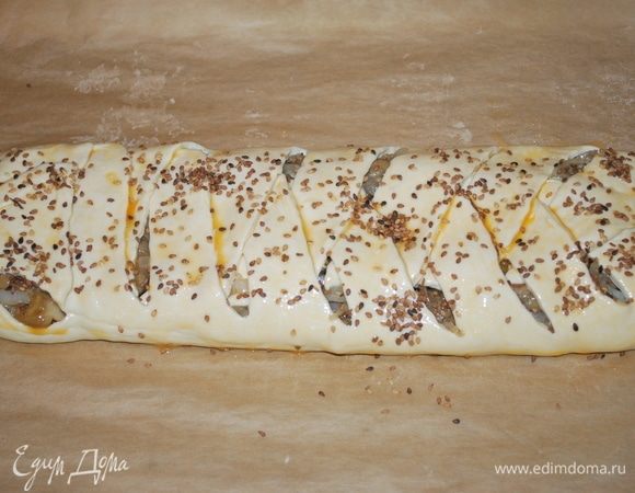 Смазать пирог желтком и посыпать кунжутом. Выпекать при 180°C в течение 25 минут.