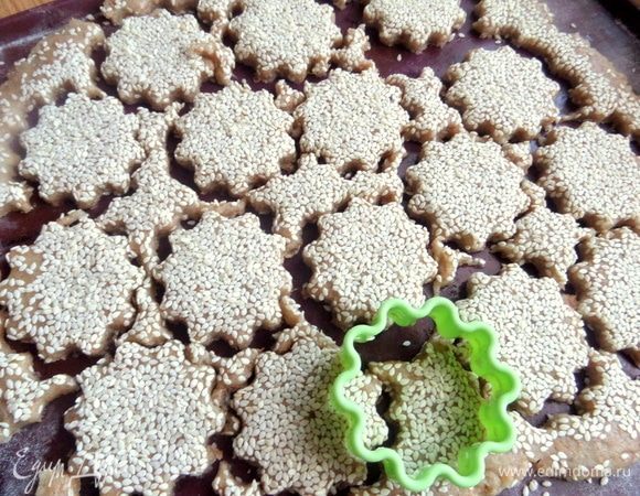 Провести скалкой по семечкам, чтобы слегка их втопить в тесто.