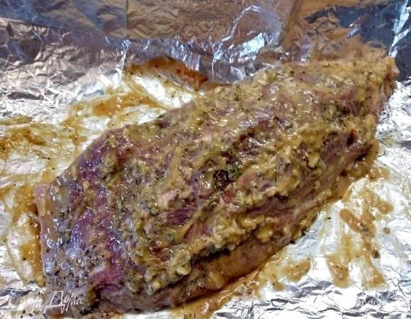 Нашпиговала его дольками чеснока, натерла солью, горчицей, острым соусом, перцем молотым черным и прованскими травами.