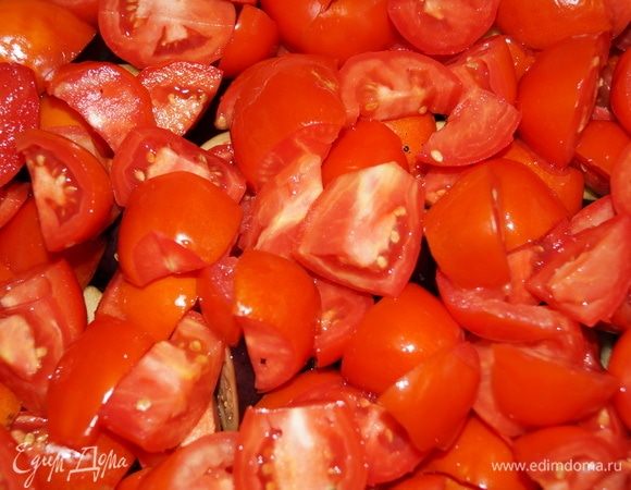 Сверху баклажанов устройте помидоры, нарезанные на дольки.