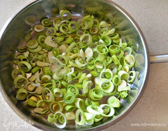 Лук-порей нарежьте тонкими кольцами, чеснок — тонкими лотиками, обжарьте 1–2 мин. на оливковом масле в отдельной сковороде.